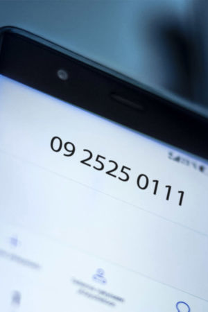Kädessä pidetään kännykkää, näytöllä kriisipuhelimen puhelinnumero 010195202.