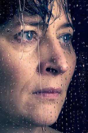 Lähikuvassa Wanda Dubiel, joka näyttelee Puhdistus-monologissa Aliide Truuta. Hänet on kuvattu vesipisaroita valuvan ikkunan läpi. 