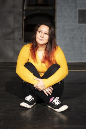 Anne Kassimäki istuu tyhjällä näyttämöllä.
