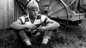 Nuori mies istuu ruohikolla
