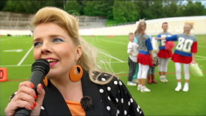 Susanna Vainiola ja cheerleaderit. Susanna Vainiola juontaa lomamatkalaisten cheerleader-esityksen Velodromilla Helsingissä.