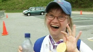 Suomen Special Olympics -joukkueen urheilija näyttää riemuiten mitaliaan.