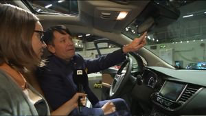 Opel Finlands vd Rami Kittilä visar hur man genom en knapptryckning kan ringa nöd- och servicesamtal via backspegeln. Rami Kittilä, vd för Opel Finland visar hur den nya teknologin i bilarna fungerar.