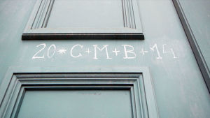 Numerot ja kirjaimet 20 C+M+B+14 liidulla harmaaseen peilioveen kirjoitettuna merkkinä Sternsingerien käynnistä.