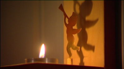 En ängel från ett änglaspel är dekorationen i en lampett