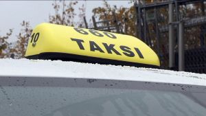 Taksi-kyltti auton katolla.