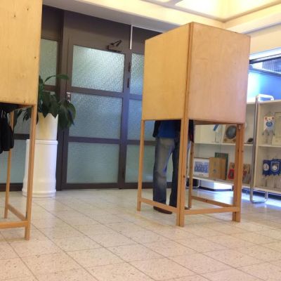 Ihmisiä äänestämässä vaalikopissa.