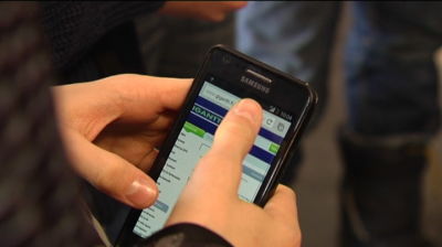 Kille håller mobiltelefon i handen