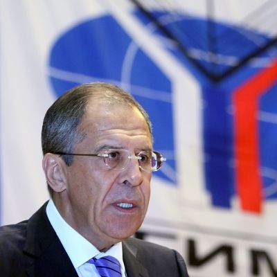Lavrov kuvattuna vuonna 2014 Ulkosuhteiden instituutissa MGIMO:ssa. Taustalla näkyy instituutin logo, sininen maapallo, jonka edessä on Y:-kirjaimen muotoinen valko-sini-punainen kuvio.