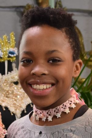 Nosipho Bahne har gjort ett choker-halsband av en handvirkad spets. Ett porträtt av en leende flicka som har på sig ett spänt halsband, så kallad choker. Halsbandet har hon gjort själv av en rosa spets och sidenband och det är dekorerat med vita, stjärnformade pärlor.