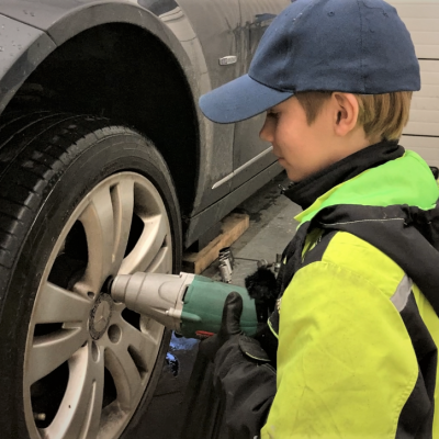 13-vuotias Aati Junttila vaihtaa autoon talvirenkaita Seinäjoella tallissa.