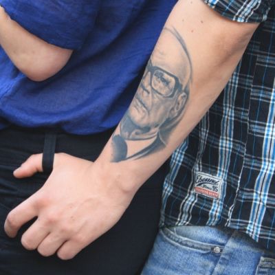 Tatuoitu käsi tytön lanteilla.