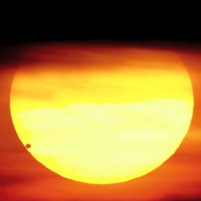Venus tummana pallona auringon alareunassa.