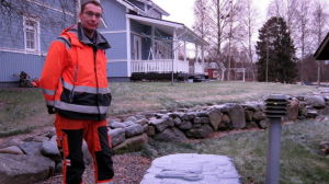 Magnus Näs i arbetskläder står invid minireningsverket som han har på sin gård