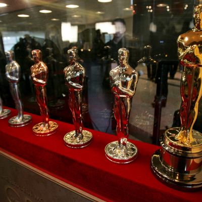 Kuusi Oscar-patsasta rivissä punaisella alustalla. Ensimmäinen on vasta ydin, viimeinen kullattu ja kiillotettu. 