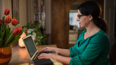 kvinna sitter vid dator och skriver