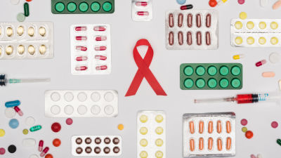 Grafik föreställande en aidsrosett, mediciner i pillserdform och en blodfylld spruta. 