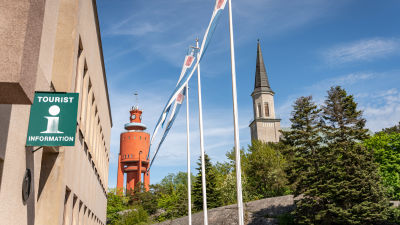 En turistinfoskylt i förgrunden och i bakgrunden Hangös vattentorn.