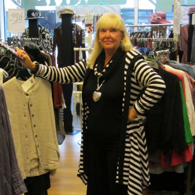 Kuvassa Hannele Ilomäki liikkeessään vaatteiden keskellä