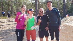 Orientering i Bromarv på World Orienteering Day 23.5.2018. På bilden Hanna Björkstrand, Virve Savoila, Tjurre Lindfors och Ville Vuorelma. En bild på fyra personer som står på rad. De har deltagit i orientering och håller i varsin kompass. De är idrottsklädda.