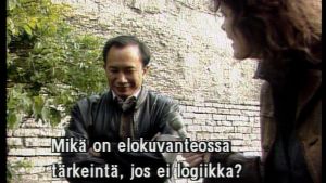 Elokuvaohjaaja John Woo Tallinnassa 1993. Kuva Noitaympyrät-ohjelman R&A-festivaaliraportista. Kysymyksen esittää toimittaja Kati Sinisalo.