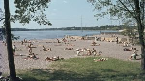 Sandstrands badstrand i Helsingfors har länge varit välbesökt av soldyrkare. Fotot taget 1968. Sadstrand med solbadande människor.