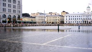 Lybeckskajen i centrala Helsingfors svämmade över 2005. I bakgrunden en temporär stormbarriär byggd av pappersavfall. Översvämning i centrala Helsingfors, 9.1.2005