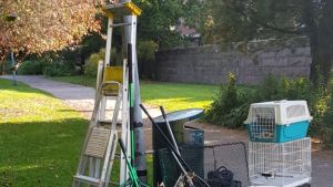 Helpparrots redskap för att fånga papegojor och andra husdjursfåglar. Burar och stegar i en park.