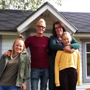 Fyra personer framför en lekstuga