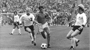 Hollantilainen Johan Cruyff oli poikkeuksellinen persoona. Cruyff (keskellä) kamppailee Länsi-Saksan Berti Vogtsia ja Uli Hoeneßia vastaan MM-finaalissa 1974 Hollantilainen Johan Cruyff oli poikkeuksellinen persoona. Cruyff (keskellä) kamppailee Länsi-Saksan Berti Vogtsia ja Uli Hoeneßia vastaan MM-finaalissa 1974