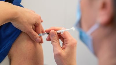 En vårdare i Raseborg ger den första sprutan åt en i vårdpersonalen den 11. januari 2021.