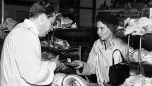 Under andra världskriget begränsades inköp med ransoneringskuponger. På bilden köper en kvinna kött med kuponger år 1941 i Stockholm. Kvinna köper kött med en ransoneringskupong i butik.