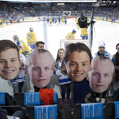 Fanit pitävät käsissään valtavia pahvipäitä