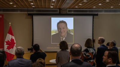 Bild av Michael Spavor visas på stor skärm.