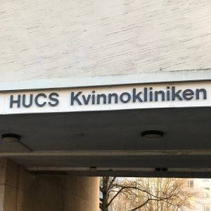 EN dörr och en portgång och en skylt på en husvägg.