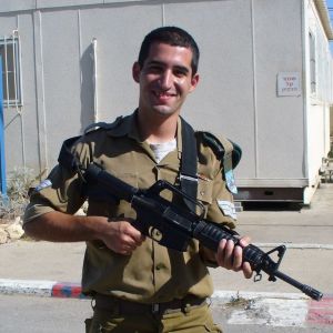 Ran Goren tjänstgjorde i Israels militär för omkring tio år sedan. En man står med en stormgevär på en asfalterad plan i solen. Han ser glad ut. Han har på sig militäruniform.