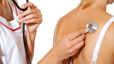 Doktorn checkar lungorna med stetoskop
