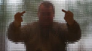 Våld är ett aggressivt beteende, men man måste inte vara arg för att ta till våld Man visar mittenfinger bakom en glasvägg.