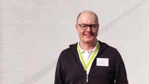 Martin von Schoultz är en van valfunktionär. En medelålders man står utomhus framför en vit vägg. Han tittar in i kameran och ler.