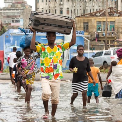Människor går på översvämmad gata i Moçambique.