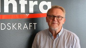 Peter Backman. En medelålders man står framför en svart vägg. På väggen står det med vit text Posintra framtidskraft.