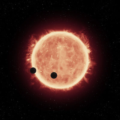En artists bild av två exoplaneter som kretsar kring en röd dvärg
