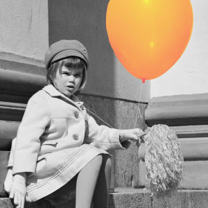 En liten flicka med en ballong och en majvippa sitter på domkyrkans trappor i Helsingfors 01.05.1966.