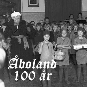 en gammal bild med julgubbe och barn som är utklädda till tomtar
