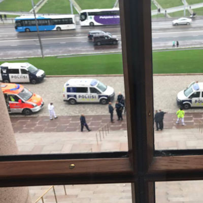 Knivhuggning utanför riksdagshuset, polisbilarna fotograferade genom ett fönster. 