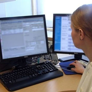 Läkare framför dator.