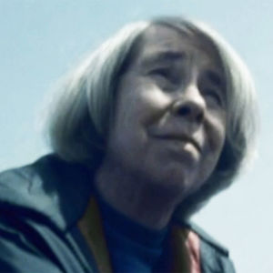 Tove Jansson istuu rantakalliolla.