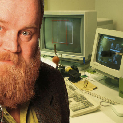 Gösta Sundqvist 1997 ja taustalla tietokoneita.