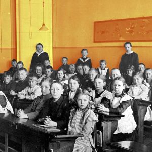 Koululaisia vuonna 1921. Oppilaat istuvat pulpeteissaan