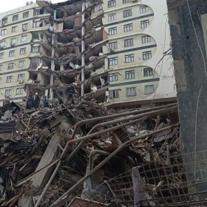 Pelastushenkilöitä raivaamassa maanjäristyksessä romahtanutta kerrostaloa.